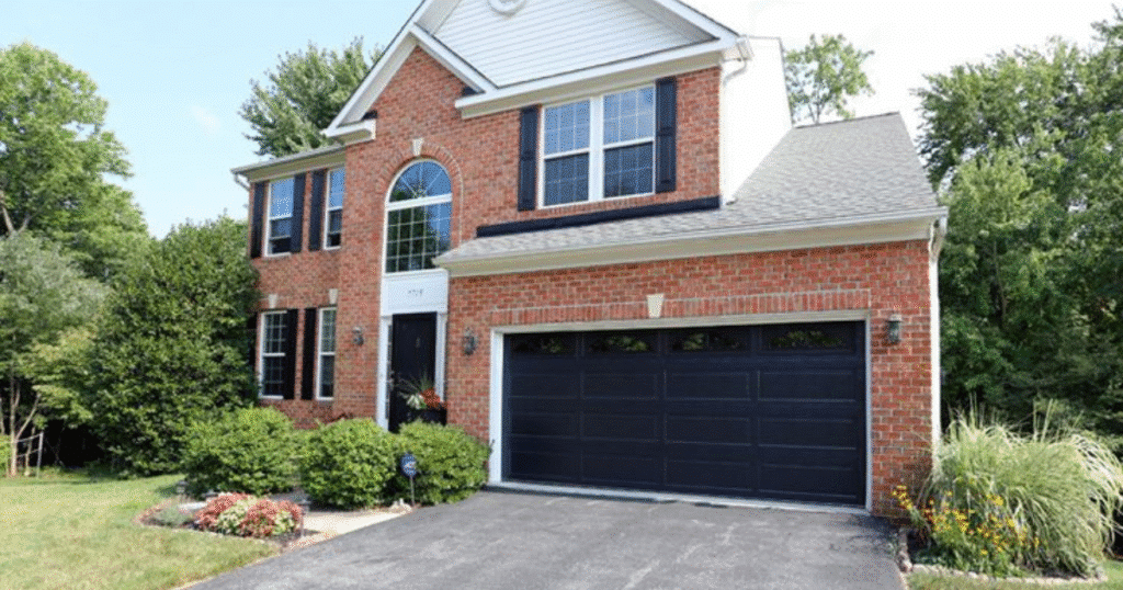 red brick house with bold black door garage